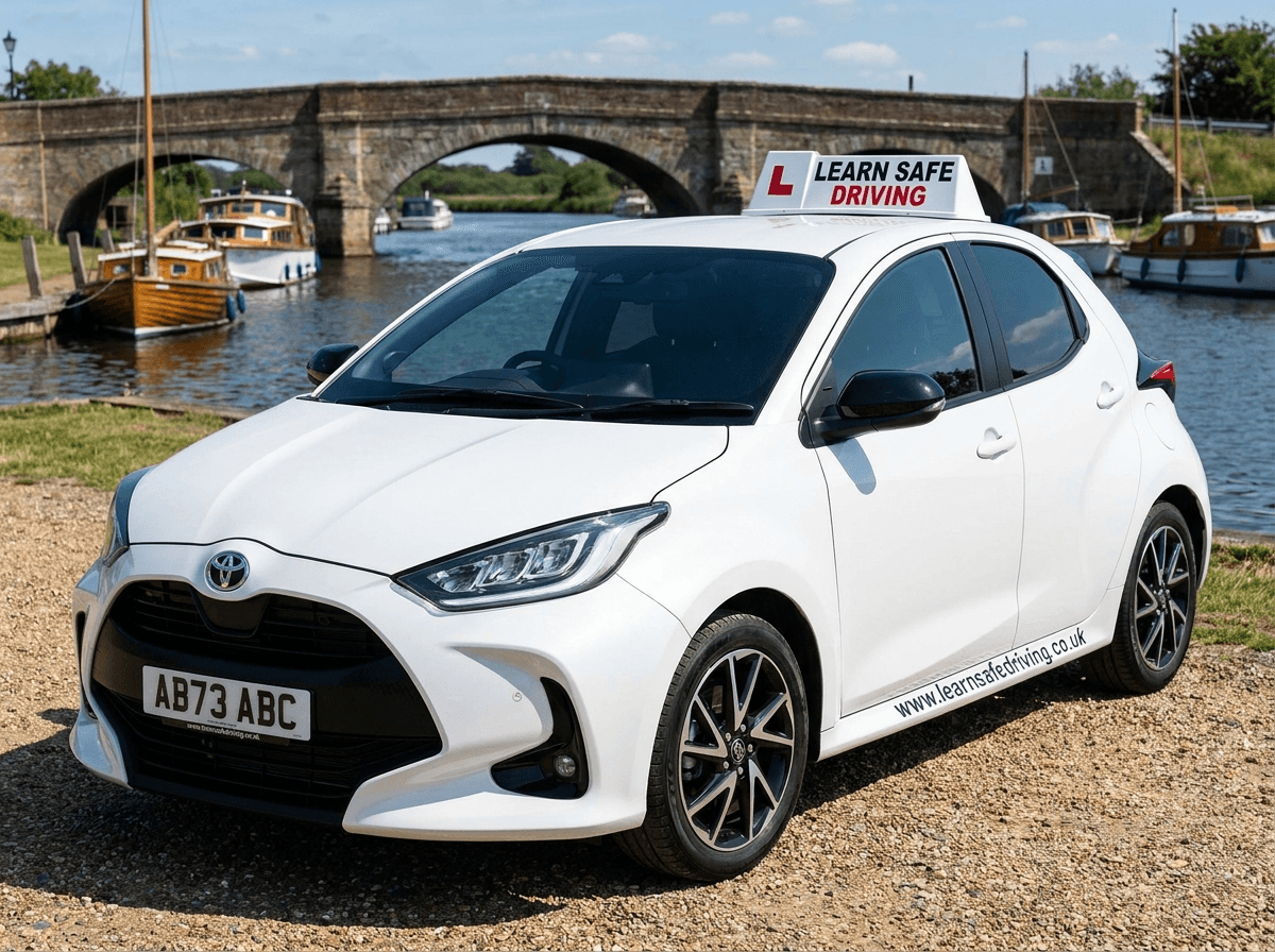 Learn Safe Driving car beside the river at Brundall, with a stone bridge and moored boats on the Norfolk Broads